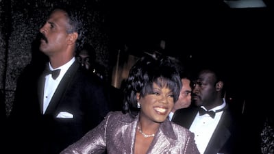 Oprah Winfrey wears a metallic purple two-piece to attend the 21st Annual Daytime Emmy Awards with Steadman Graham on May 25, 1994. Getty Images