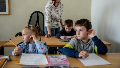 Teacher Katja with Artem, Sofia and Alexander, refugee schoolchildren who are receiving Ukrainian curriculum primary school education in Berlin, Germany. Getty