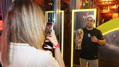 A fan gets his hands on a mock World Cup trophy at Bla Bla by McGettigan's in JBR, Dubai. Chris Whiteoak / The National