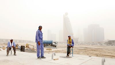 Labourers take a break during a blowing sandstorm near Zabeel Park in Dubai. Sarah Dea / The National