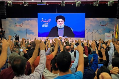 Lebanese Hezbollah leader Hassan Nasrallah is cheered by his supporters as he speaks through a giant screen on the occasion of the group's "martyr's day" in the capital Beirut's southern suburb. AFP