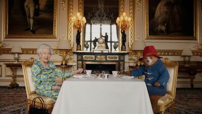 Queen Elizabeth II and Paddington Bear having cream tea at Buckingham Palace in a film that was shown at BBC's 'Platinum Party at the Palace'. Reuters