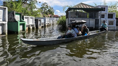 People visit the graves of relatives by boat on All Saints' Day, in the flooded Hagonoy Public Cemetery in Bulacan, Philippines. Reuters