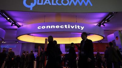 Visitors walk past the Qualcomm stand at the Mobile World Congress in Barcelona. Albert Gea / Reuters