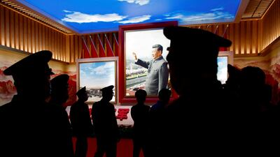Members of the Chinese People's Liberation Army (PLA) walk past an image of Mr Xi at an exhibition at the Military Museum of the Chinese People's Revolution in Beijing. Reuters