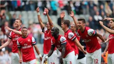 Arsenal players celebrate their victory Sunday, which secured fourth place in the table. Ian MacNicol / AFPn