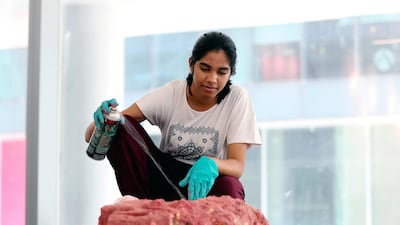 Aditi Monga sprays her suitably craterous design with red paint. Chris Whiteoak / The National