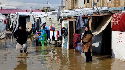 Syrian refugees stand in a pool of mud and rain water at a refugee camp, in the town of Bar Elias, in the Bekaa Valley, Lebanon, Thursday, Jan. 10, 2019. AP