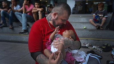 Baba Mujhse holds a newly-arrived migrant baby in front of the Keleti railway station in Budapest, Hungary. Bela Szandelszky/AP Photo