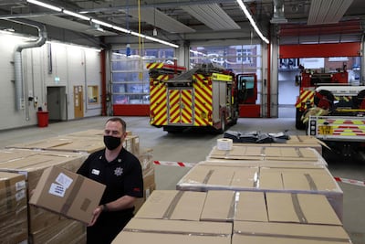A firefighter stacks boxes of coronavirus Covid-19 testing kits at Woking fire station in Surrey, where the South African variant was identified. AFP