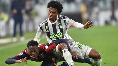 Juventus' Juan Cuadrdo, right, and Christian Kouame of Genoa. EPA