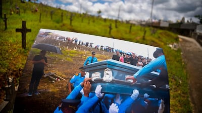 A printed photo taken on September 29, 2017 showing police lifting the coffin of officer Luis Angel Gonzalez Lorenzo, who was killed in the hurricane. The local police force of Aguadilla and Aguada is down by about a dozen officers since the storm, due to resignations and retirements.