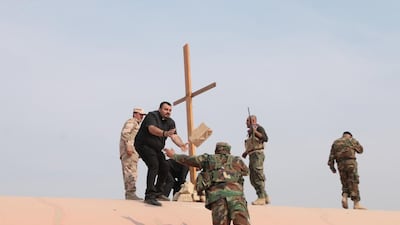 Father Amar and Father Majid erect a cross – with the help of Christian militiamen – on the roof of the heavily damaged Church of the Immaculate Conception in Qaraqosh, Iraq, on October 25, 2016. Florian Neuhof for The National