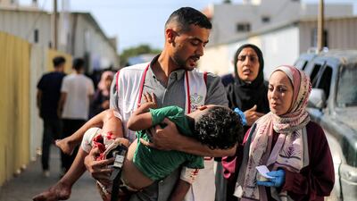 A wounded child is carried to Al Awda Hospital in Nuseirat, central Gaza. AFP