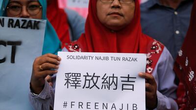 A supporter of former Malaysian prime minister Najib Razak holds up a sign, ahead of his arrival to court in Kuala Lumpur, Malaysia. REUTERS/Lai Seng Sin