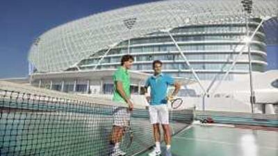 Roger Federer, right, and Rafael Nadal pose for the media after playing tennis on the Formula One track at Yas Island Hotel yesterday.