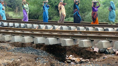 Workers repair railway tracks washed away by floods in the western state of Gujarat. Raveendran / AFP