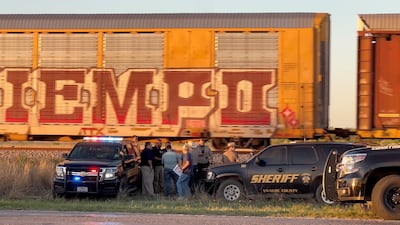 Police officers gather near a railway line in Uvalde, Texas, where a group of migrants was discovered on board a freight train. Reuters