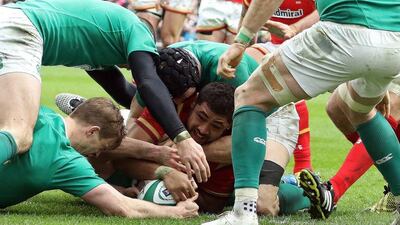 Wales' number 8 Taulupe Faletau (C) scores his team's first try during the Six Nations international rugby union match between Ireland and Wales at the Aviva Stadium in Dublin, Ireland, on February 7, 2016. / AFP / PAUL FAITH