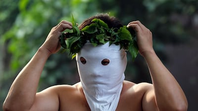 A penitent prepares his mask during Good Friday in San Juan village, San Fernando, Pampanga, Philippines. Thousands of Catholic devotees witnessed dozens of men who were nailed to wooden crosses or flogged themselves bloody in annual rituals re-enacting the crucifixion of Jesus Christ. EPA