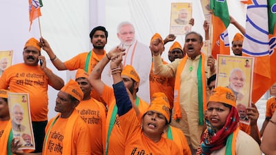 Supporters stand beside a cardboard cut-out of India's Prime Minister Narendra Modi. T Narayan / Bloomberg