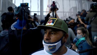 A fan of Diego Maradona stands outside the clinic where he underwent surgery for a subdural haematoma. Reuters