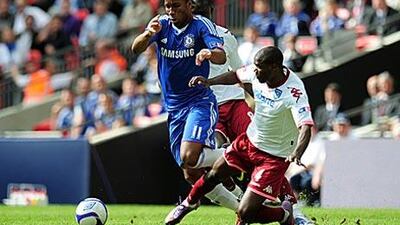 Didier Drogba, left, is fouled by Portsmouth's Aaron Mokoena. The Chelsea striker scored the resulting free-kick to hand the London club a league and FA Cup double.