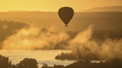 A hot air balloon rises over Lake Burley-Griffin at sunrise during the Canberra Balloon Festival in Canberra, Australia. EPA