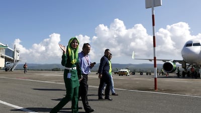 An airline stewardess wearing a hijab waves as she crosses the tarmac at Sultan Iskandar Muda Airport in Aceh, Indonesia, on January 31, 2018. Hotli Simanjuntak / EPA