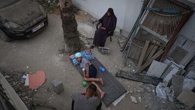 Wadih Ghaben, 11, a displaced Palestinian boy with a gunshot wound, lies on a mattress outside the special operating room due to intense heat