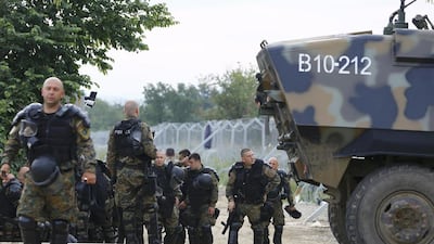 Police stand next to an armoured vehicle parked on a railway line. The government’s spokesman for the refugee crisis, Giorgos Kyritsis, said Monday that police would not use force, and that the operation was expected to last about a week to 10 days. Ognen Teofilovski / Reuters