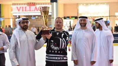 Dubai Mighty Camels ice hockey team captain Ron Murphy, centre, with the EHL Cup. Courtesy photo