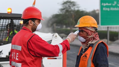 A worker has his temperature checked before entering a worksite in Kuwait City. EPA