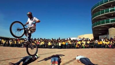 A bicycle rider performs tricks outside the Mbombela Stadium, in Nelspruit, South Africa. The stadium in the Mpumalanga province is to host several matches in the FIFA World Cup Soccer Tournament which gets under way June 11.