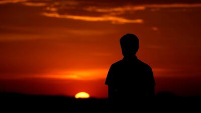 A man watches the sunset in Kansas City. Daylight saving time starts Sunday in most states in the US as clocks are advanced by one hour. AP
