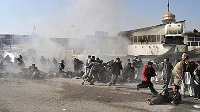 People flee as after an explosion at a Shiite shrine in Kabul during Ashura, as blasts across Afghanistan leave at least 55 people dead.