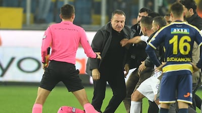 Referee Halil Umut Meler holds his head after being punched. EPA