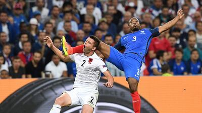France left-back Patrice Evra, right, puts in a high challenge on Albania’s Andi Lila. Franck Fife / AFP