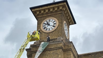 Firefighters on a cherry picker speak to the protester. PA