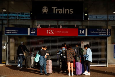 Travellers stand outside the closed entrance to the Gatwick Express train service at Victoria Station in London. Reuters