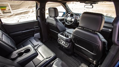 The truck is equipped with a rear-view camera and rear parking sensors, while the centre console houses a slide-out work table.