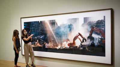 Museum staff pose during a photocall for ‘Wim Wenders: Photographing Ground Zero’ exhibition at the Imperial War Museums (IWM) in London on September 10, 2021. (Photo by Tolga Akmen / AFP) / RESTRICTED TO EDITORIAL USE - MANDATORY MENTION OF THE ARTIST UPON PUBLICATION - TO ILLUSTRATE THE EVENT AS SPECIFIED IN THE CAPTION