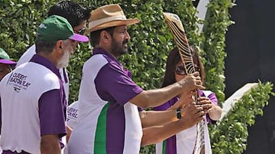 Suresh Kalmadi, centre, chairman of the Commonwealth Games organising committee takes the Queen's baton after it arrived in India from Pakistan at the checkpoint at Attari, about 30 km from the northern city of Amritsar.