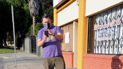 An Eddie Van Halen fan photographs a makeshift memorial for the late musician near Van Halen's childhood home in Pasadena, California. AP