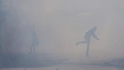Kashmiri protesters throw rocks and bricks at Indian policemen amid tear gas smoke during a protest in Srinagar, Indian controlled Kashmir. Police fired teargas and rubber bullets to disperse hundreds of Kashmiris who gathered to protest against the arrest of separatist leaders and civilians. Dar Yasin / AP