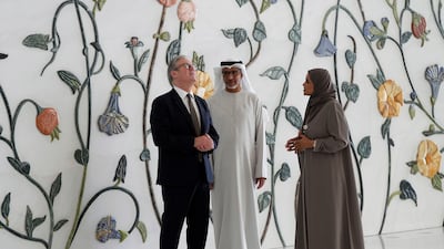 Mr Starmer is led by director general Yousef Al Obaidli and a tour guide, Mahra, during his visit. AP