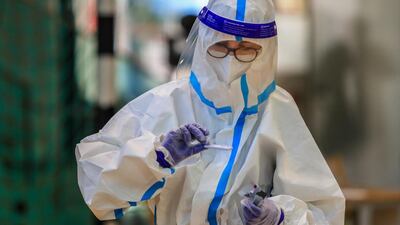 A healthcare worker holds a kit while performing a test in a school sports hall in Bolzano, South Tyrol. AFP