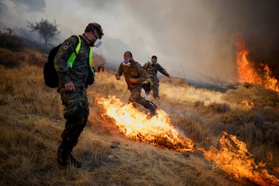Volunteers try to extinguish a wildfire burning in the village of Markati, near Athens,. Reuters