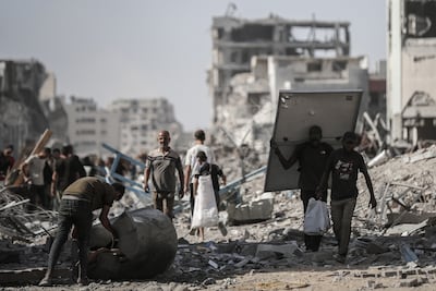 Palestinians salvage items from the rubble in Gaza city on Friday after being allowed to return by Israel. Bloomberg