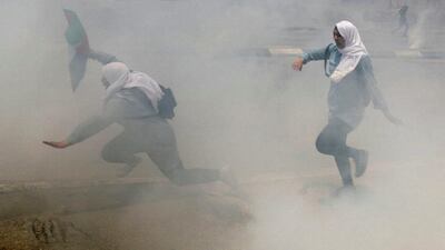 Palestinian school girls run for cover from tear gas fired by Israeli troops during clashes at a protest to mark the 69th anniversary of the nakba, in the West Bank town of Bethlehem on May 15, 2017. Ammar Awad / Reuters